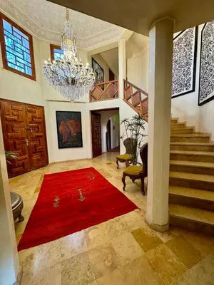 a living room with a red rug and stairs at Villa Ross in Marrakech