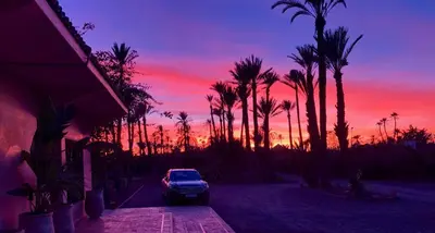 a car parked in front of a house with a sunset at Villa Ross in Marrakech