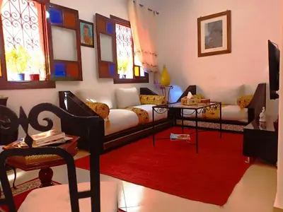 a living room with a couch and a red rug at DAR AZIZ in Marrakech