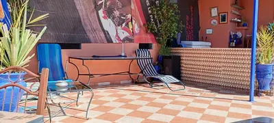 a room with two chairs and a table and some plants at DAR AZIZ in Marrakech