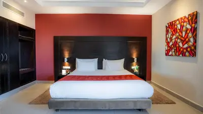 a bedroom with a large bed with a red wall at Kech Boutique Hotel in Marrakech
