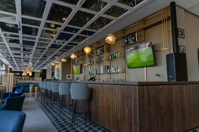 a bar with chairs and a tv on the wall at Kech Boutique Hotel in Marrakech