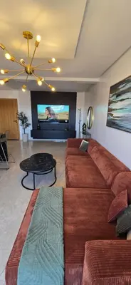 a living room with a large couch and a table at Luxueux appartement entre Gueliz et l'Hivernage avec WIFI in Marrakech