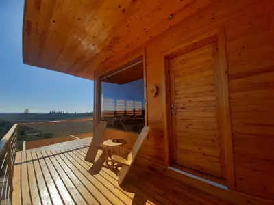 a wooden cabin with two chairs and a table on a deck at Le Parc des Oliviers Ecolodge in Marrakech