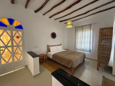 a bedroom with a bed and a large window at Le Parc des Oliviers Ecolodge in Marrakech