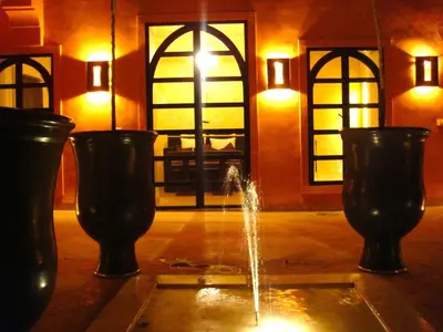 a fountain in a room with three black vases at Riad Hermès in Marrakech