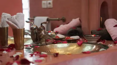 a bathroom sink with pink flowers on a counter at Riad Ahlsouss in Marrakech