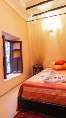 a bedroom with two beds and a window at Riad Ahlsouss in Marrakech