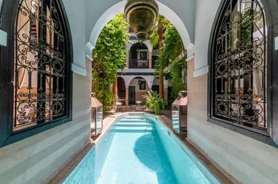 an indoor swimming pool in a building with windows at Riad Espoir, Riad de charme en exclusivité dans la médina de Marrakech in Marrakech