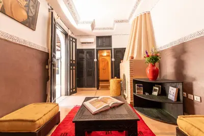 a living room with a table with a book on it at Riad Espoir, Riad de charme en exclusivité dans la médina de Marrakech in Marrakech