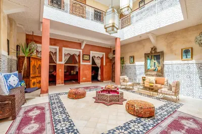 a large living room with tables and couches at Riad 7 chambres - Petit dejeuner gratuit in Marrakech