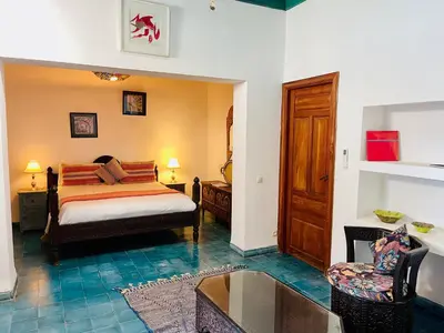 a bedroom with a bed and a chair and a table at Riad Zarka By La Siredrah in Marrakech
