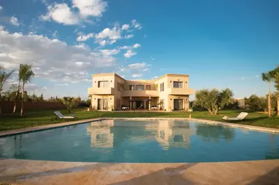 a large house with a swimming pool in front of it at LE JASMIN DE MARRAKECH in Marrakech