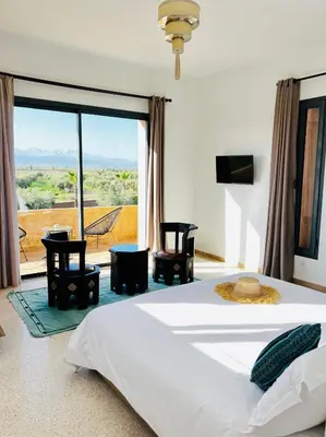 a bedroom with a large bed and a large window at LE JASMIN DE MARRAKECH in Marrakech