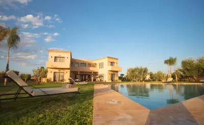 a house with a swimming pool in front of a house at LE JASMIN DE MARRAKECH in Marrakech