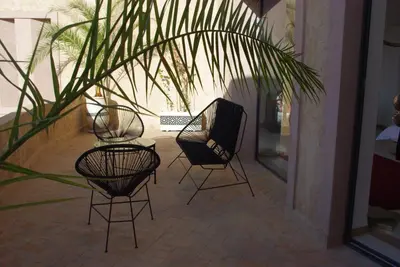 a group of chairs and a table and a plant at LE JASMIN DE MARRAKECH in Marrakech