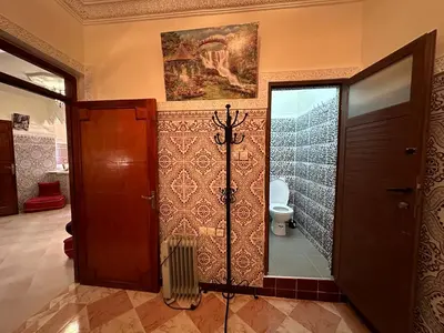a bathroom with a toilet and a painting on the wall at Cosy appartement in Marrakech