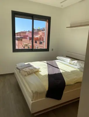 a bedroom with a large bed with a window at Appartement avec terrasse au calme en plein centre de Marrakech tres rare in Marrakech