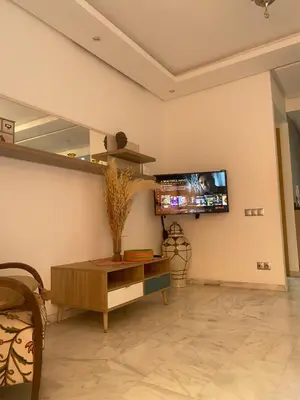 a living room with a tv on the wall at Appartement avec terrasse au calme en plein centre de Marrakech tres rare in Marrakech