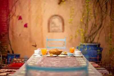 a table with a plate of food and two glasses of orange juice at Riad Persephone in Marrakech
