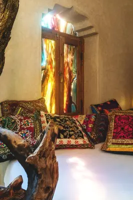 a room with a bed with pillows and a fireplace at Riad Persephone in Marrakech