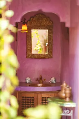 a purple bathroom with a sink and a mirror at Riad Persephone in Marrakech
