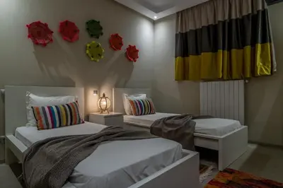 two beds in a room with flowers on the wall at VILLA MARIA - Famille uniquement in Marrakech