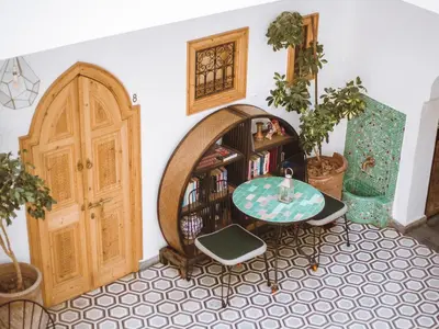 a room with a table and a book shelf at Riad Le Petit Joyau in Marrakech