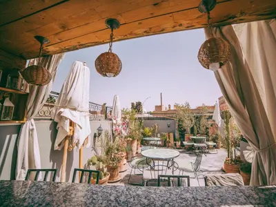 an outdoor patio with a table and chairs at Riad Le Petit Joyau in Marrakech