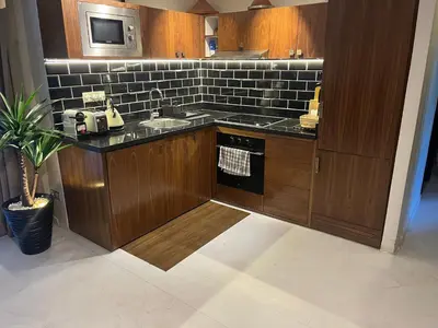 a kitchen with wooden cabinets and a sink and a stove at Appartment Rhizlane in Marrakech