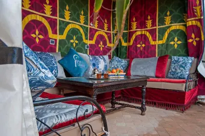 a living room with a couch and a table at Riad Merzouga in Marrakech