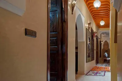 a hallway with a wooden door in a building at Riad Merzouga in Marrakech