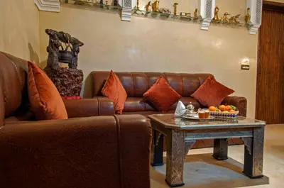 a living room with a brown leather couch and a table at Riad Merzouga in Marrakech