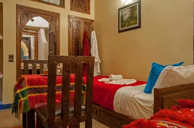 a bedroom with two beds and a mirror at Riad Merzouga in Marrakech