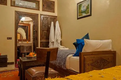 a bedroom with a bed and a mirror and a chair at Riad Merzouga in Marrakech