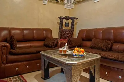 a living room with a leather couch and a table at Riad Merzouga in Marrakech