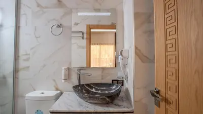 a bathroom with a bowl sink on a marble counter at Ourika Camp Suites Hotel & Resort in Marrakech
