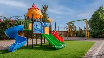 a childrens playground with a slide and a slideintend at Ourika Camp Suites Hotel & Resort in Marrakech