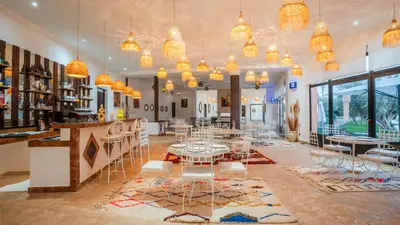 a room with tables and chairs and chandeliers at Ourika Camp Suites Hotel & Resort in Marrakech