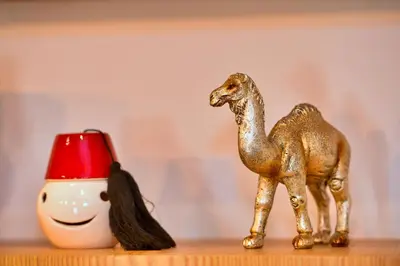 a gold toy camel on a shelf with a red hat at Appartement de prestige climatisé à l'hivernage 400m de la Gare in Marrakech