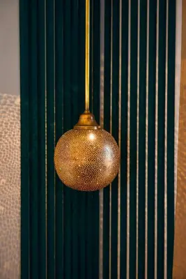 a gold light fixture hanging from a green wall at Appartement de prestige climatisé à l'hivernage 400m de la Gare in Marrakech
