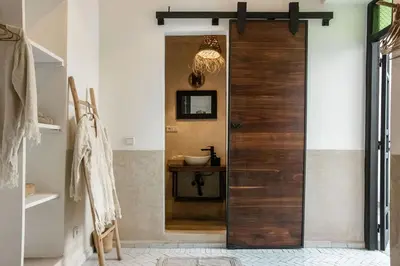 a wooden door in a bathroom with a sink at Riad Darsahalia in Marrakech