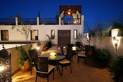 a patio with tables and chairs in front of a building at Riad Assakina in Marrakech