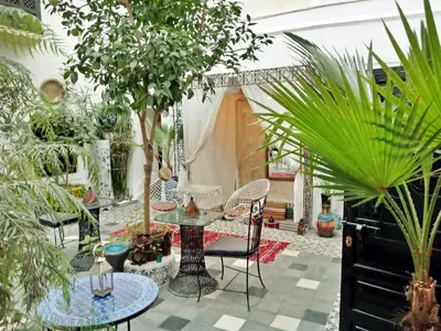 a courtyard with tables and potted plants at Riad Gaya in Marrakech