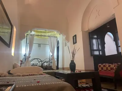 a bedroom with a bed and a mirror and a table at Riad Gaya in Marrakech
