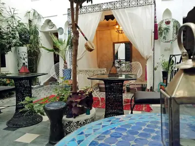 a room with tables and chairs and plants at Riad Gaya in Marrakech