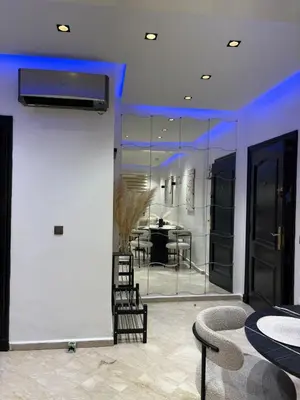 a living room with a table and chairs and a wall at Hivernage - Stylish APT in the Heart of the City in Marrakech