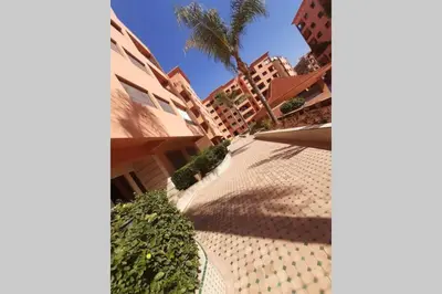 a view of a courtyard with a palm tree and buildings at Hivernage - Stylish APT in the Heart of the City in Marrakech