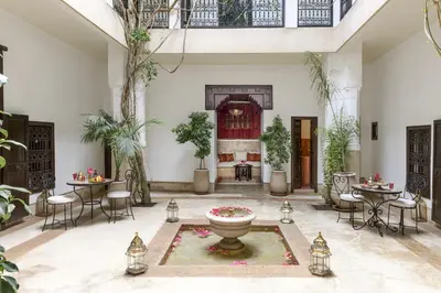 a courtyard with a fountain and tables and chairs at Riad Hayati in Marrakech