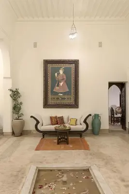 a living room with a couch and a painting on the wall at Riad Hayati in Marrakech